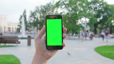 Eine-Hand-hält-eine-Telefon-mit-einem-Green-Screen