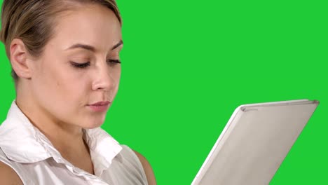 Young-attractive-business-woman-holding-a-tablet-computer-on-a-Green-Screen,-Chroma-Key