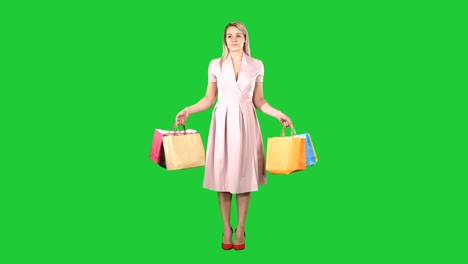 Mujer-con-bolsas-de-compras-en-vestido-rosa-que-está-parado-en-una-pantalla-verde-Chroma-Key