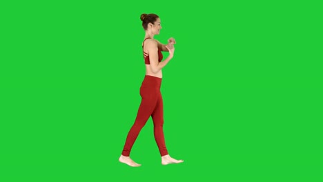 Feminine-sportswoman-stretching-her-arms-during-walk-on-a-Green-Screen,-Chroma-Key