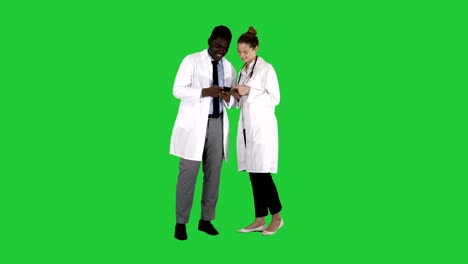 Medical-team-looking-at-phone-together-on-a-Green-Screen,-Chroma-Key