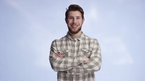 Young-and-good-looking-man-walking-into-the-frame-smiling-and-crossing-his-arms