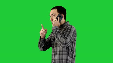 Side-portrait-of-a-happy-student-walking-and-talking-on-mobile-phone-on-a-Green-Screen,-Chroma-Key