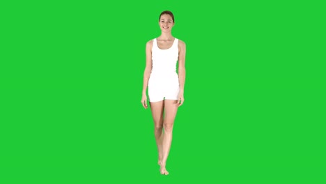 Junge-sexy-Frau-zu-Fuß-und-lächelnd-gekleidet-in-weißen-Shorts-und-T-shirt-auf-einem-Green-Screen,-Chroma-Key