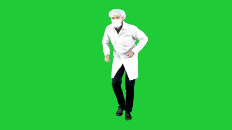 Arzt-seine-Uniform-trägt-und-trägt-eine-Maske,-die-er-zu-in-eine-lustige-Art-und-Weise-auf-einem-Green-Screen,-Chroma-Key-Fuß