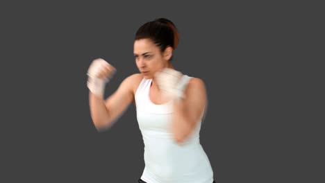 Fit-brunette-punching-mit-bandaged-Fäuste