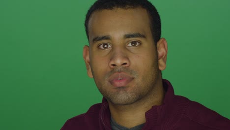 Young-African-American-man-looking-intimidating,-on-a-green-screen-studio-background