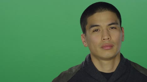 Young-man-looks-sad,-on-a-green-screen-studio-background