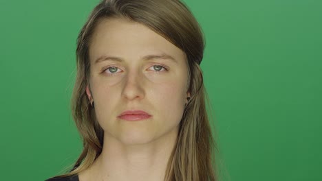 Junge-Frauen-sieht-traurig-und-weint-und-wischt-eine-Träne-auf-einem-green-Screen-Studio-Hintergrund