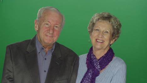 Elderly-woman-kisses-elderly-man,-on-a-green-screen-studio-background