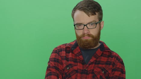 Young-bearded-man-poses-with-attitude,-on-a-green-screen-studio-background