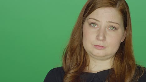 Young-redhead-woman-looking-concerned-and-upset,-on-a-green-screen-studio-background