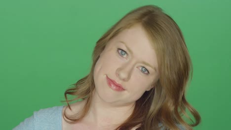 Schöne-Brünette-Frau-Grimassen-und-lächelnd-auf-einem-green-Screen-Studio-Hintergrund