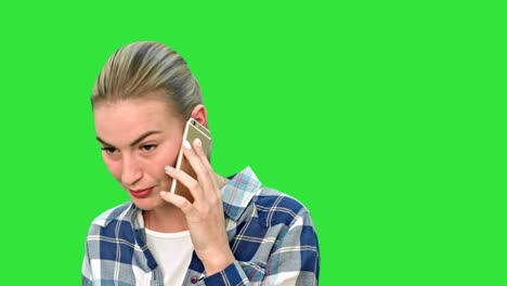 Beautiful-young-woman-talking-on-mobile-phone-seriously-on-a-Green-Screen,-Chroma-Key