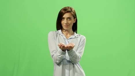 Woman-presents-a-virtual-gift-on-a-mock-up-green-screen-in-the-background.