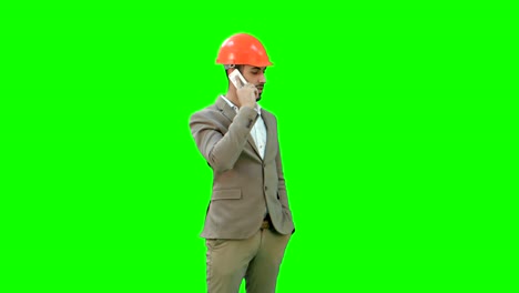 Auftragnehmer-im-Helm-auf-seinem-Handy-auf-einem-Green-Screen,-Chroma-Key-im-Gespräch