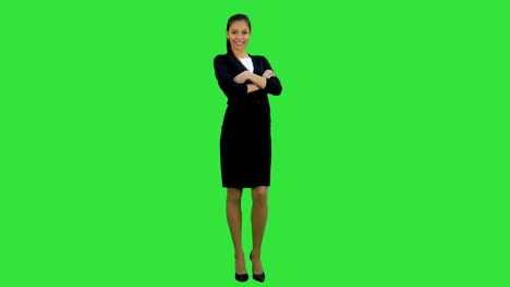 Flirty-young-woman-winking-at-camera-and-waiving-her-hand-on-a-Green-Screen,-Chroma-Key