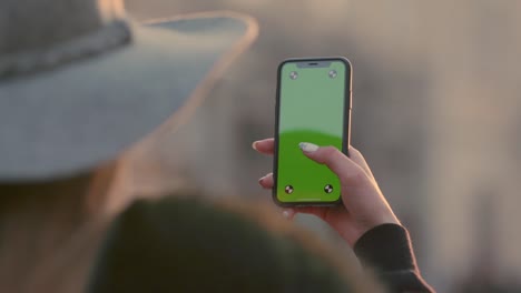 Woman-holding-green-screen-smartphone