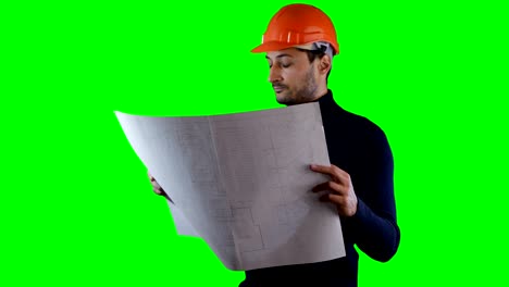 Ein-Mann-in-sicheren-Helm-lesen-Blaupausen-in-der-green-Screen,-Chroma-Key-Hintergrund