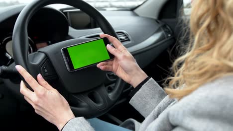 Frau-sitzt-in-das-moderne-Auto-und-mit-Smartphone---Closeup-Hände.-Green-Screen.-Chroma-key