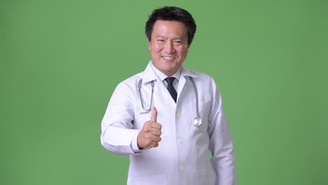 Mature-Japanese-man-doctor-against-green-background