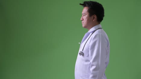 Mature-Japanese-man-doctor-against-green-background