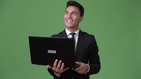 Young-handsome-Hispanic-businessman-against-green-background