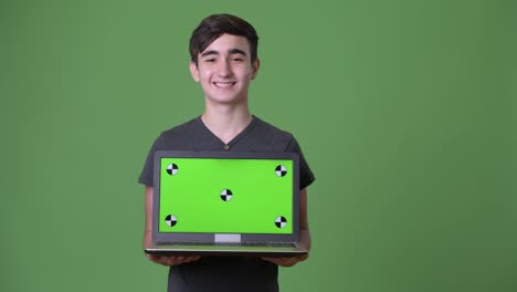 Young-handsome-Iranian-teenage-boy-against-green-background