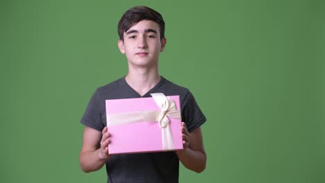 Young-handsome-Iranian-teenage-boy-against-green-background