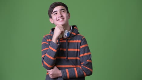 Young-handsome-Iranian-teenage-boy-against-green-background