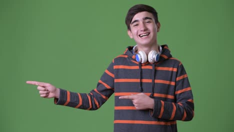 Young-handsome-Iranian-teenage-boy-against-green-background