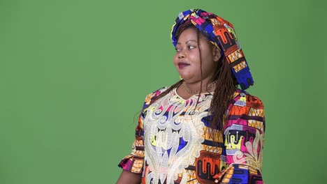 Overweight-beautiful-African-woman-wearing-traditional-clothing-against-green-background