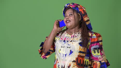 Overweight-beautiful-African-woman-wearing-traditional-clothing-against-green-background