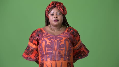 Overweight-beautiful-African-woman-wearing-traditional-clothing-against-green-background