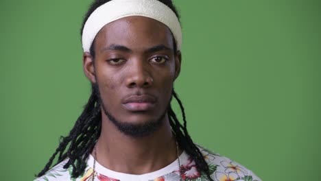 Young-handsome-African-man-with-dreadlocks-against-green-background