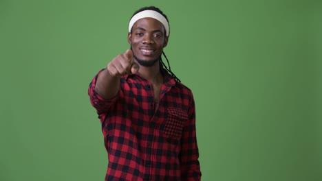 Young-handsome-African-man-with-dreadlocks-against-green-background