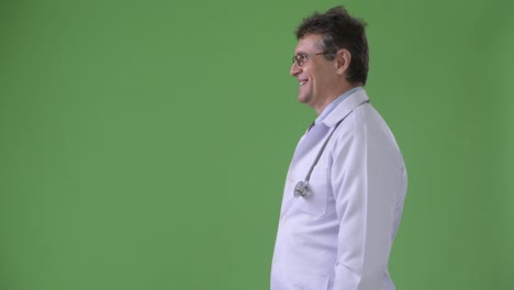 Mature-handsome-man-doctor-against-green-background