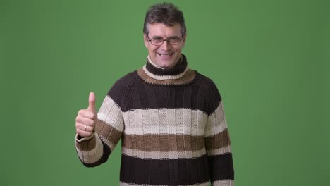 Mature-handsome-man-wearing-turtleneck-sweater-against-green-background