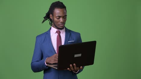 Joven-empresario-africano-hermoso-con-rastas-sobre-fondo-verde