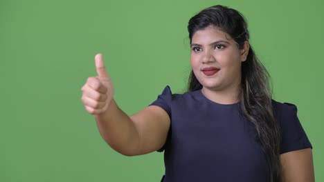 Young-overweight-beautiful-Indian-businesswoman-against-green-background