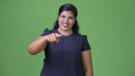 Young-overweight-beautiful-Indian-businesswoman-against-green-background