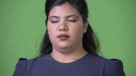 Young-overweight-beautiful-Indian-businesswoman-against-green-background