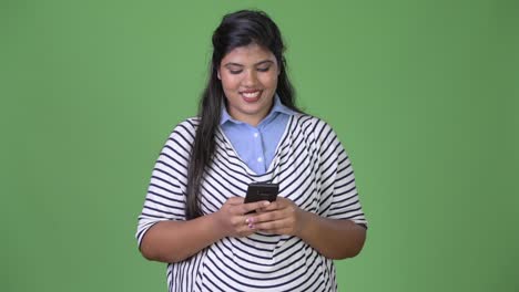 Young-overweight-beautiful-Indian-businesswoman-against-green-background