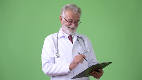 Handsome-senior-bearded-man-doctor-against-green-background