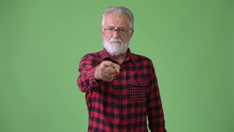 Handsome-senior-bearded-man-against-green-background