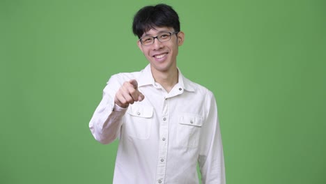 Young-Asian-businessman-smiling-and-pointing-to-camera