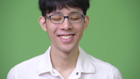 Happy-young-Asian-businessman-smiling-while-relaxing-with-eyes-closed