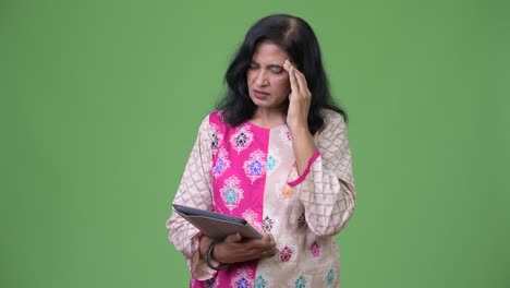 Mature-stressed-Indian-woman-using-digital-tablet-and-getting-bad-news