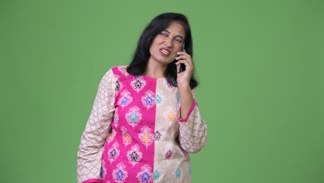 Mature-beautiful-Indian-woman-thinking-while-talking-on-the-phone