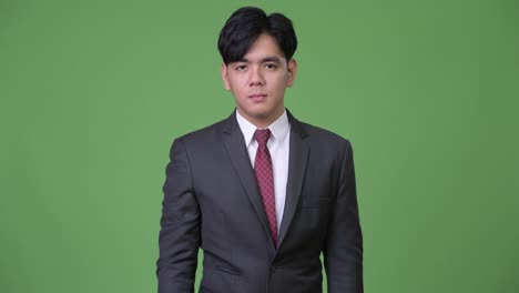 Young-handsome-Asian-businessman-pointing-to-camera